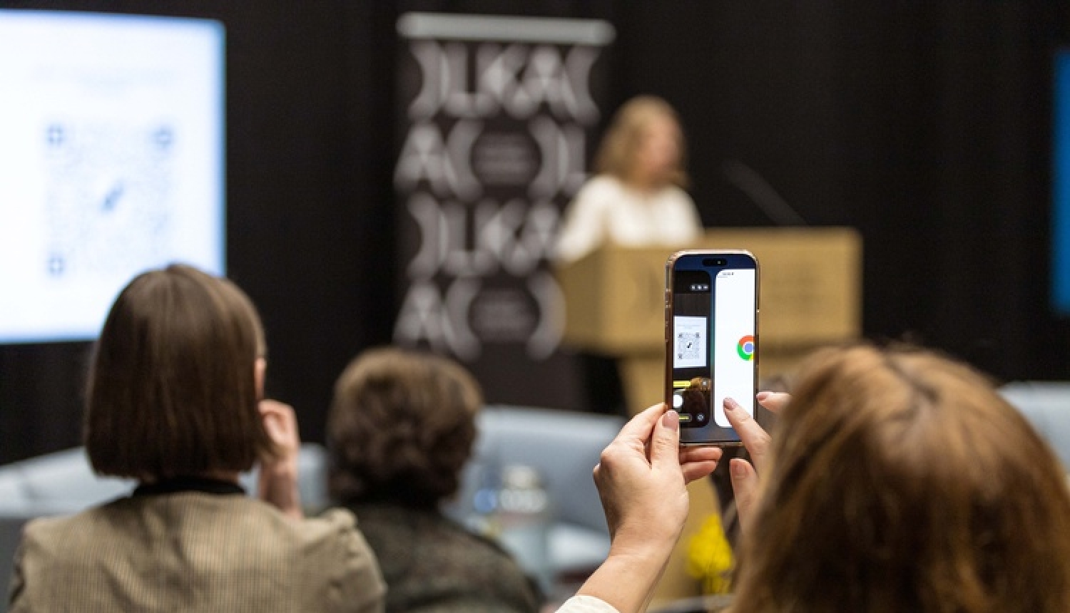 Valsts pētījumu programmas CERS noslēguma konference. Konferences apmeklētāja ar telefonu fotografē notiekošo.
