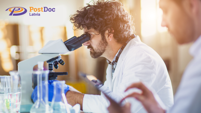 Pētnieki laboratorijā skatās mikroskopā