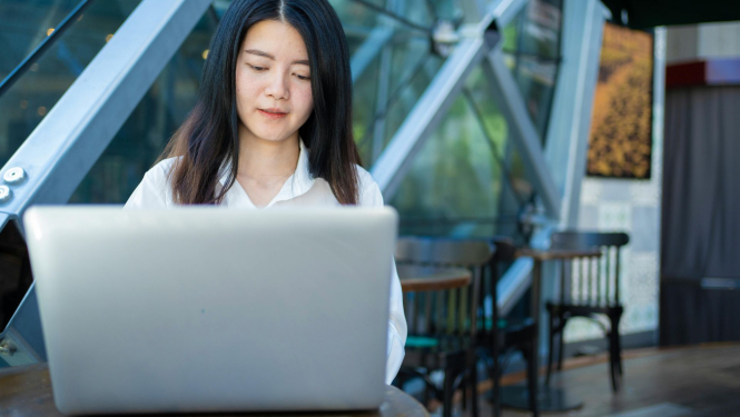 Sieviete sēž pie atvērta datora