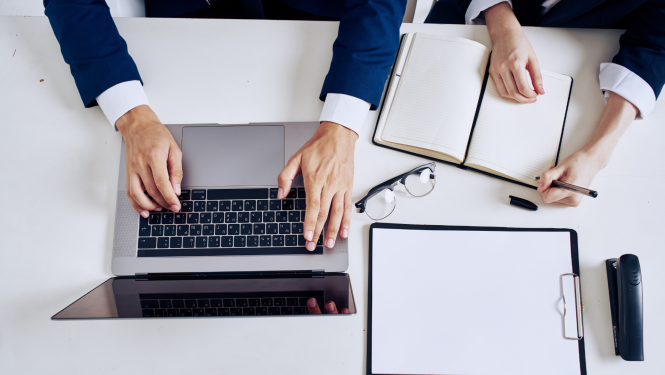 Piezīmjdators, biroja piederumi, piezīmju bloks,brilles, dokumenti,skats no augšas