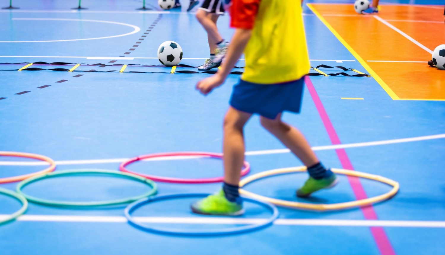 Bērns sporta zālē izpilda vingrojumu